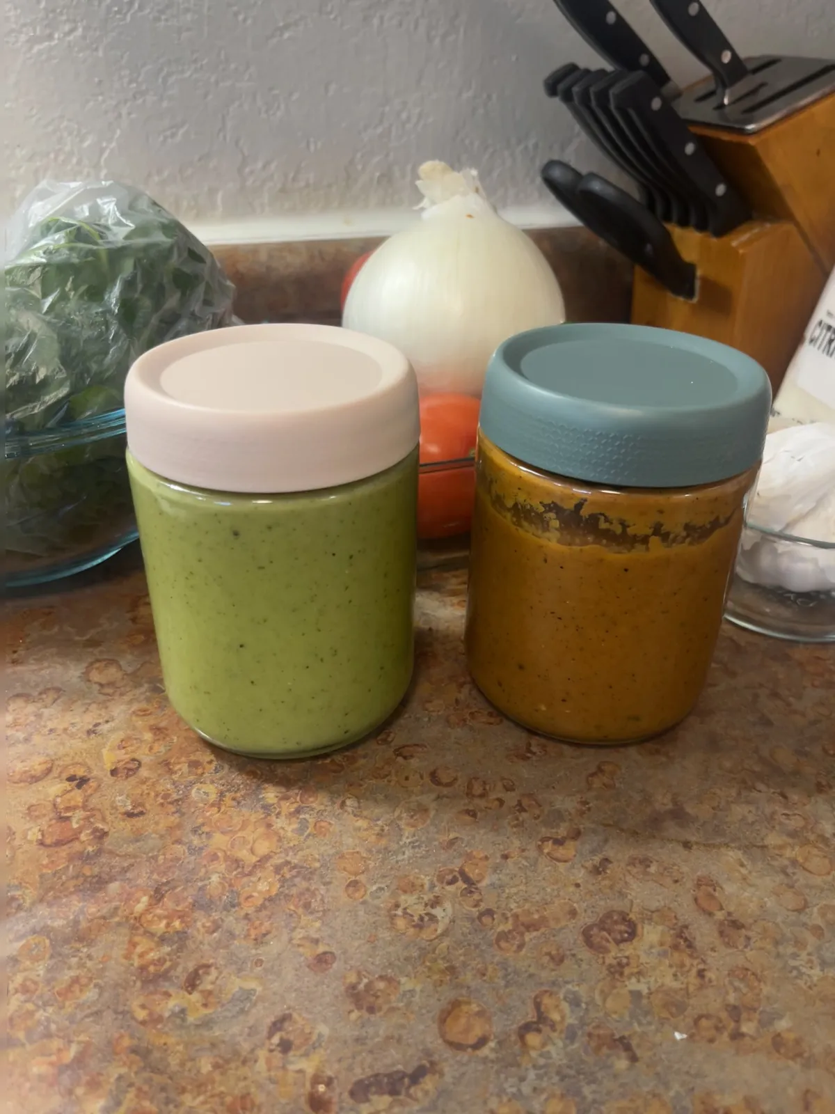 Two jars of finished salsa — verde on the left, roja on the right